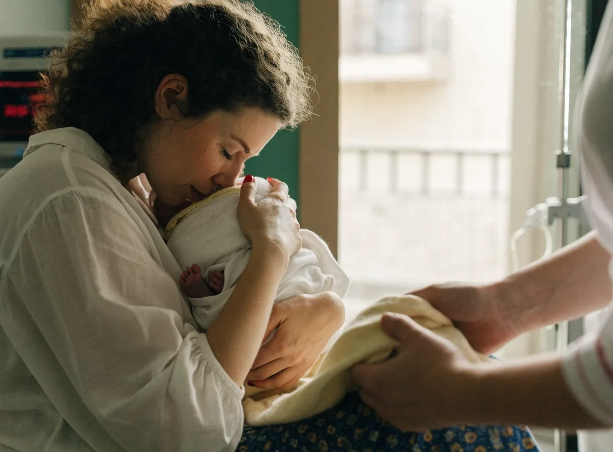 Madre joven sosteniendo a su recién nacido en una habitación luminosa de un hospital en España